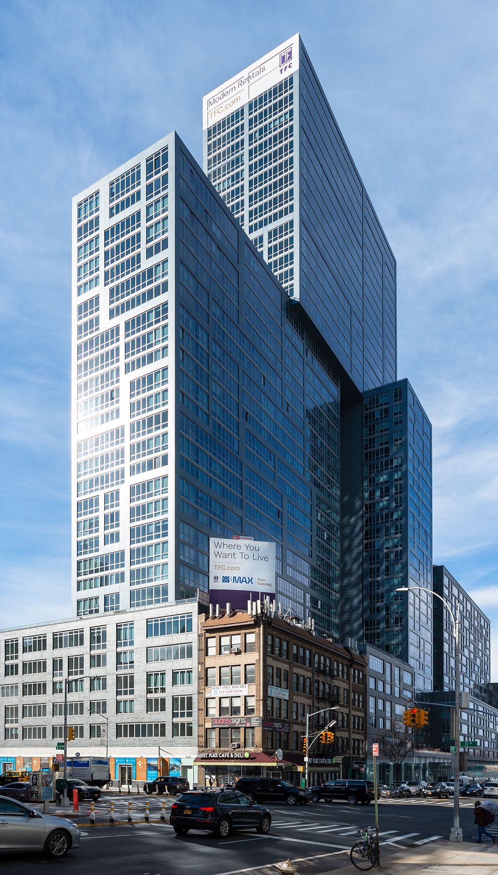 Photograph of 606 W 57th St during the day from a block away, showing the entire building