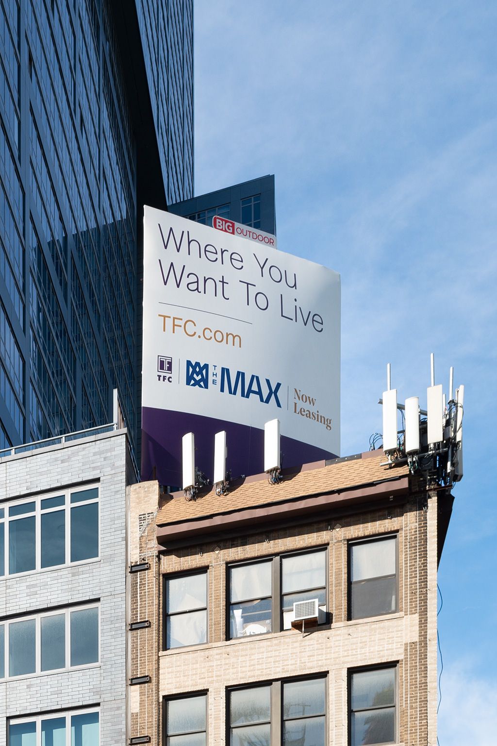 Photograph of a billboard on top of a building in NYC during the day